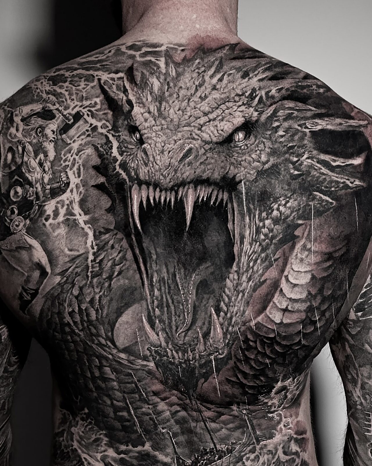 Duży czarno-szary tatuaż smoka na plecach – Electric Sheep Tattoo Szczecin